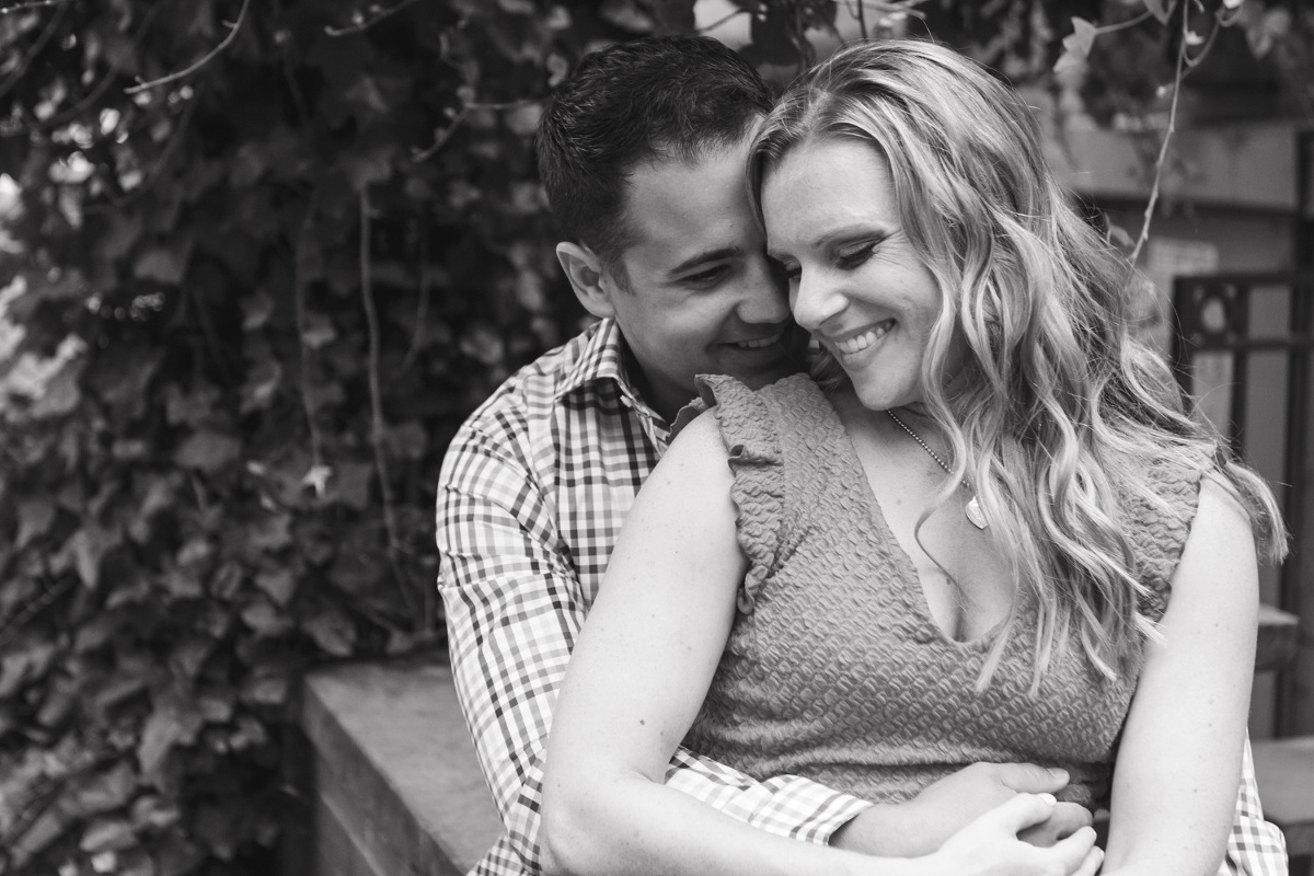 Black and white photo of couple sitting and snuggling near pike place market and post alley