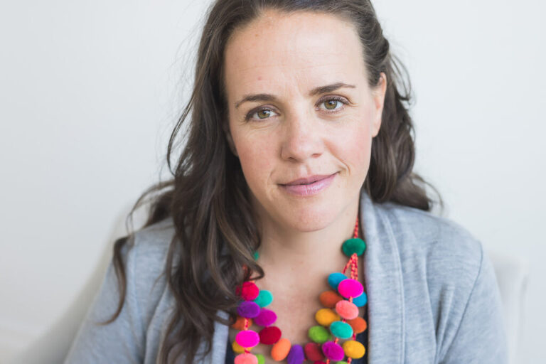 headshot of woman with colorful necklace
